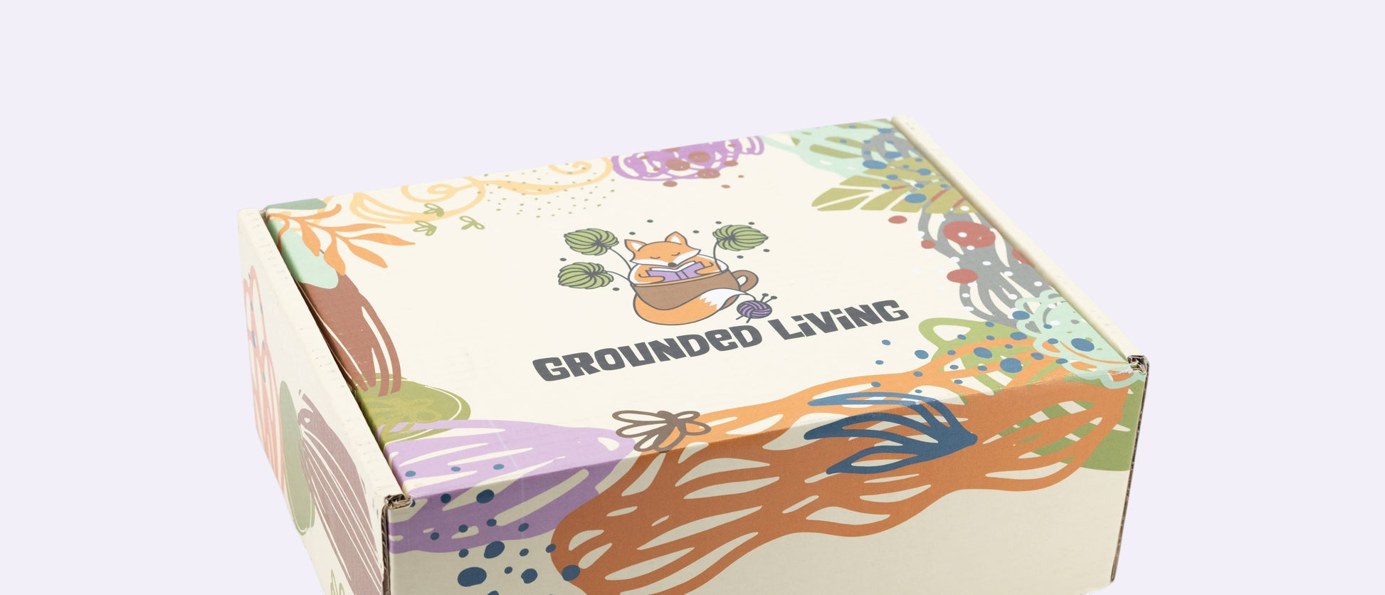 Colorful box with 'Grounded Living' branding and nature-themed illustrations on a white background
